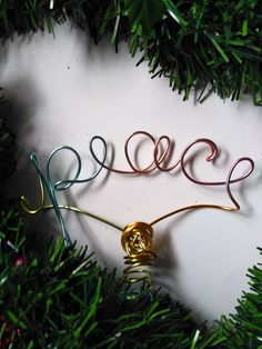 a christmas ornament hanging from a tree with the word peace written on it