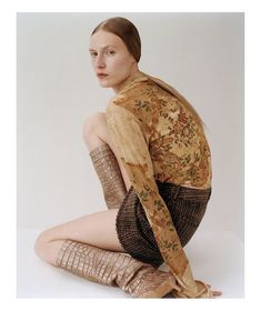 a woman is sitting on the floor with her legs spread out and wearing boots,