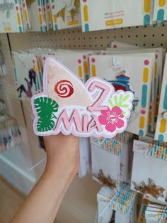 a person holding up a sticker with the word mia on it in front of a store display