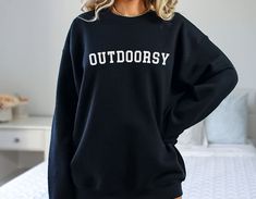 "Outdoorsy Sweatshirt Camping Sweatshirt Travel Crewneck Adventure Shirt Hiking Sweatshirt Gift For Her Sweatshirts for Women Order Instructions: 1. Check and review all photos 2. Select the sweatshirt size and sweatshirt color from drop down menus 3. Click \"Add to cart.\" You can also go back to add more products or you can complete the checkout process. 4. Click \"Proceed to check out.\" Product Description: This unisex heavy blend crewneck sweatshirt is made with polyester and cotton. The ri Letter Print Crew Neck Top For Outdoor, Casual Crew Neck Top For Outdoor Activities, Casual Crew Sweatshirt For Outdoor, Oversized Letter Print Tops For Outdoor, Winter Casual T-shirt For Outdoor Activities, Casual Sweater With Graphic Print For Outdoor Activities, Casual Crew Neck Sweatshirt For Outdoor Activities, Trendy Long Sleeve Tops For Outdoor, Casual Sweatshirt With Letter Print For Outdoor Activities