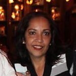 a woman is smiling for the camera in front of some people at a restaurant or bar