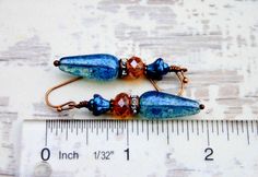 Rustic Copper dangles with beautiful blue & amber Czech glass beads & sparkly crystal copper rings...Uniquely Beautiful! Uniquely hand crafted with these quality materials: ~ Czech glass fire polished faceted beads ~ Crystal encrusted copper spacer rings ~ Antiqued copper findings & lead & nickel-free French style ear wires ~ Silicone earring backs to keep earrings securely in ears Measuring 2 inches from the top of the ear wires to the bottom of the beads, they're light weight & Adjustable Blue Bohemian Teardrop Earrings, Blue Bohemian Crystal Drop Earrings, Bohemian Blue Crystal Drop Earrings, Handmade Blue Bohemian Crystal Earrings, Bohemian Blue Beaded Hypoallergenic Earrings, Bohemian Blue Hypoallergenic Beaded Earrings, Vintage Blue Hypoallergenic Earrings, Blue Hypoallergenic Vintage Earrings, Blue Teardrop Bohemian Crystal Earrings