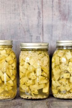 three jars filled with food sitting on top of a table