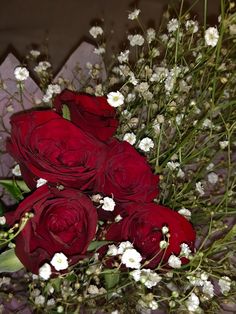 a bouquet of red roses and baby's breath