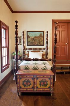 a bed sitting in the middle of a bedroom next to two windows and a painting on the wall