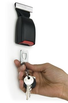 a hand holding a key to a door with a black and red handle on it