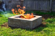 a concrete fire pit sitting on top of a lush green field