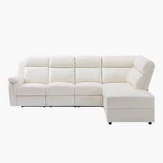 a white leather sectional sofa sitting on top of a white floor next to a footstool