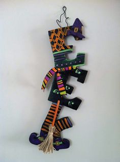 a decorative wall hanging made out of wood and fabric with a witch's hat on top