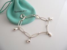 Offered for sale is a gorgeous and rare Tiffany & Co.
Peretti Sterling Silver 5 Charm bracelet.  Very pretty and unique
Tiffany piece that you will get your money's value for.  It is a
wonderful piece that looks very contemporary, chic and cool. The
bracelet is made from bright, substantial and solid Tiffany silver -
with 5 gorgeous and classic Peretti Charms dangling from it - an Open
Heart, a Teardrop, a Sirius Star, a Bean,  and a pretty Dove.   The
piece looks great worn alone, bu Tiffany And Co Bean Bracelet, Freshwater Pearl Jewelry Tiffany & Co., Sterling Silver Bracelets Women Tiffany & Co., Tiffany Charm Bracelets Tiffany & Co., Sirius Star, Tiffany And Co Bracelet, Dangle Bracelet, Gold Link Bracelet, Contemporary Chic