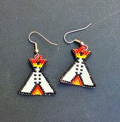 The cutest little tee pee earrings will be a fun addition to your earring collection! Brickstitch in white with accent colors. Southwest flavor will go great with jeans and casual wear. Approximately 1 inch in length on silver tone ear wires. Find us at: www.shelainescreations.store Shelaines Creations @Facebook.com Shelaine2015 @ yahoo.com  www.instagram.com/shelaine2015 www.pinterest.com/shelaine0207 Beaded Teepee Earrings, Casual White Beaded Earrings, Native Earrings, Tee Pee, Beaded Earrings Diy, Earring Collection, Earrings Diy, Brick Stitch, Plastic Canvas Patterns