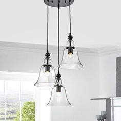 three lights hanging from the ceiling in a kitchen