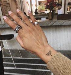 a woman's hand with two rings on it