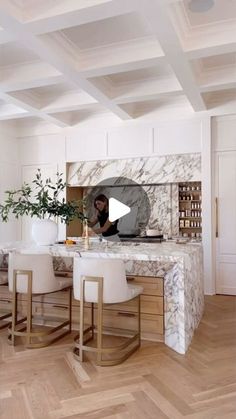 a kitchen with marble counter tops and white chairs