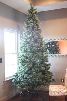 a small christmas tree sitting in the corner of a room