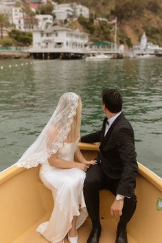 a bride and groom are sitting in a boat