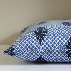 a blue and white pillow sitting on top of a table