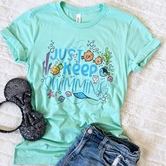 a t - shirt that says just keep swimming next to some shorts and flip flops