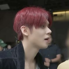 a young man with red hair is talking to someone