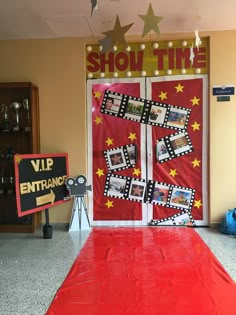 a red carpet with pictures on it in front of a show time sign and door