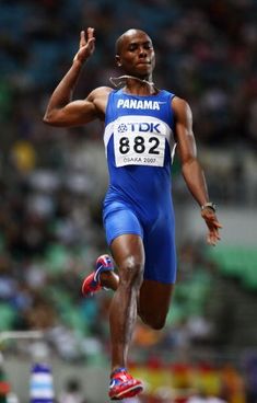 professional athlete in action on his way to winning the men's 100m hurdles