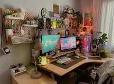 a desk with two computer monitors and a cat sitting on the chair next to it