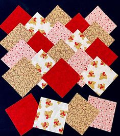 several pieces of red and white fabric are arranged on a black surface, with gold polka dots in the center