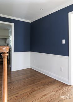 an empty room with blue walls and wood floors