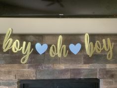 a fireplace with the words boy ohh and blue hearts on it in gold foil