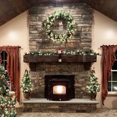 a fireplace decorated for christmas with wreaths and lights