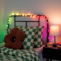 a bed with green and white checkered bedspread next to a night stand