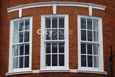 a red brick building with three white windows