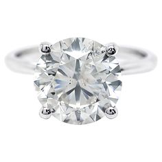 a round brilliant cut diamond ring on a white background