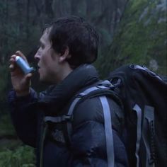 a man with a backpack is drinking from a water bottle