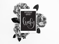 an ipad sitting on top of a bouquet of flowers with the words happy birthday next to it