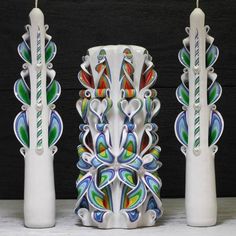 three white vases with colorful designs on them