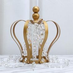 a golden crown with crystal beads on it's sides sitting on a white surface