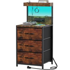 a wooden cabinet with drawers and an electronic device in the top drawer, on wheels