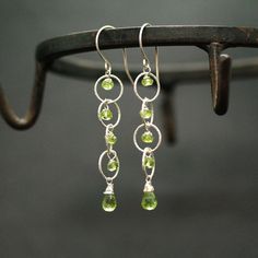 "Peridot Silver Earrings Peridot drops Briolettes and beads are wrapped with high quality sterling silver and wire and enclosed within a rings of a large link silver chain. Light weight elegant and simple. Perfect for special occasion or casual everyday wear. Mesurements: Peridot Briolette : 10mm The earrings drop around 2\" from the bottom of the hook. Ready to Ship. All items are shipped in a jewelry gift box with Shoshka Boutique logo. *Please Note that my jewelry contain an actual gemstones Peridot Dangle Earrings With Ear Wire, Dangle Peridot Gemstone Earrings, Peridot Gemstone Dangle Earrings, Silver Dangle Peridot Earrings, Silver Peridot Dangle Earrings, Jasmine Halloween Costume, Princess Jasmine Cosplay, Adult Fairy Costume, Princess Jasmine Costume