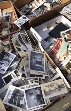 an old box filled with lots of black and white photos on top of a table