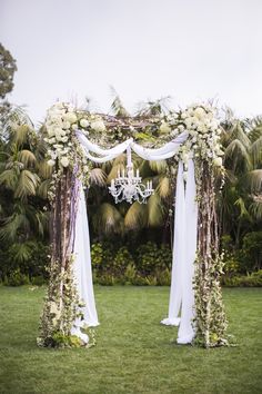 an outdoor wedding setup with chandelier and flowers