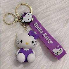 a hello kitty keychain with a purple bow on it