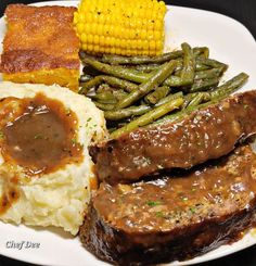 a plate with meat, mashed potatoes, green beans and corn on the cob