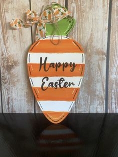 an orange and white painted wooden sign that says happy easter