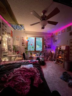 a bedroom with purple lighting and pictures on the wall above the bed in front of a window