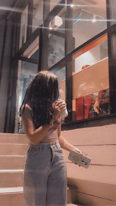 a woman standing on the steps drinking from a cup