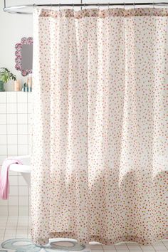 a bathroom with a white shower curtain and polka dot print on the shower curtain rod