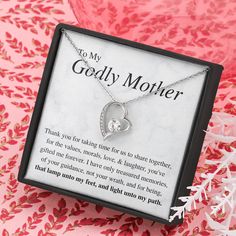 a mother's necklace in a gift box on a pink tablecloth with flowers