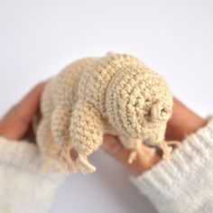 a hand holding a small crocheted gerbil in it's palm