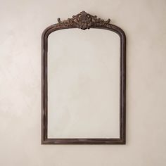 an ornate wooden mirror hanging on the wall